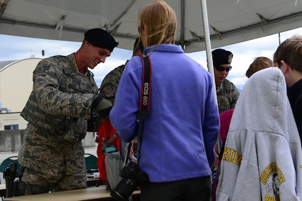 Senior Airman Riley Jorgenson, 446th Security Forces Squadron, inspects an attendee’s bag at the 2016 Arctic Thunder Open House.