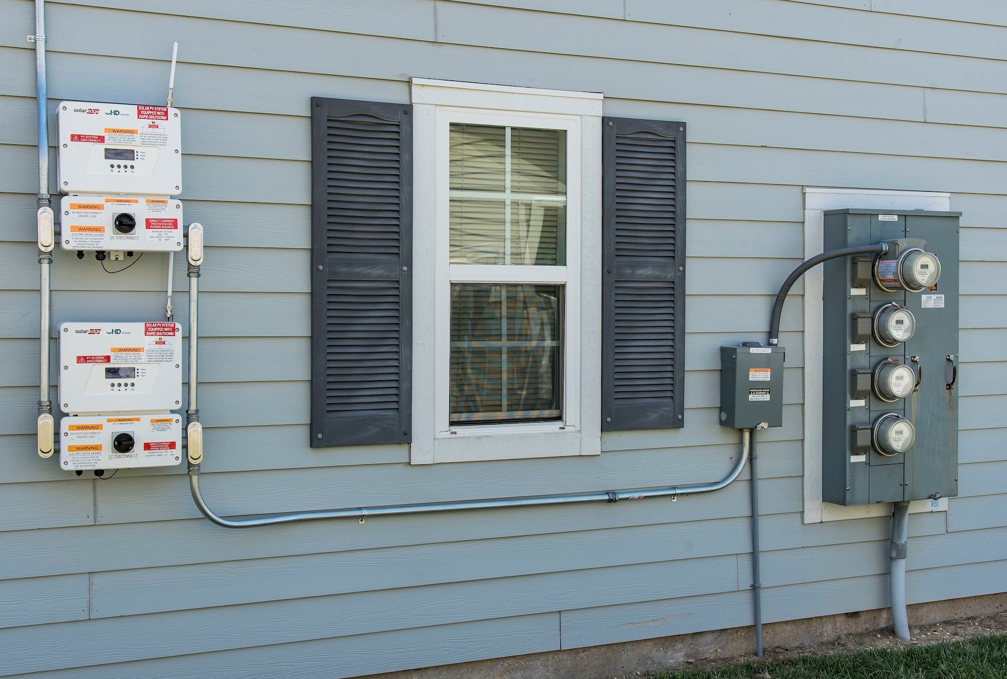 Electricity generated by photovoltaic (PV) panels is directed to inverter units prior to entering the electrical grid May 11, 2018, in the Dover Family Housing community at Dover Air Force Base, Del. Electricity generated by PV panels is transmitted to the electrical grid, not the individual house, thus reducing Hunt Military Communities’ cost for purchasing electricity from local sources. (U.S. Air Force photo by Roland Balik)