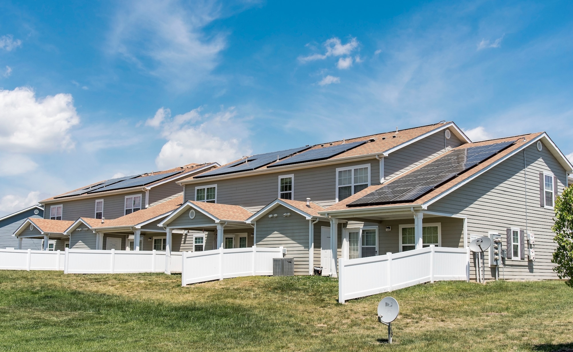 Photovoltaic (PV) panels installed on the back side of housing units in the Dover Family Housing community absorb sunlight to generate electricity May 11, 2018, at Dover Air Force Base, Del. Electricity generated by PV panels is transmitted to the electrical grid, not the individual housing units. Occupants will not see a reduction in their electricity bill. (U.S. Air Force photo by Roland Balik)
