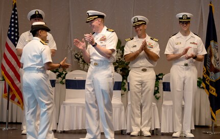 U.S. Navy Rear Adm. Babette Bolivar Navy, Region Southeast commander, left, congratulates U.S. Navy Capt. Robert Hudson, front center, outgoing deputy commander of Joint Base Charleston and commanding officer of Naval Support Activity Charleston, on his time in service here during a change of command ceremony June 25, 2018, at the Red Bank Club, JB Charleston’s Naval Weapons Station.