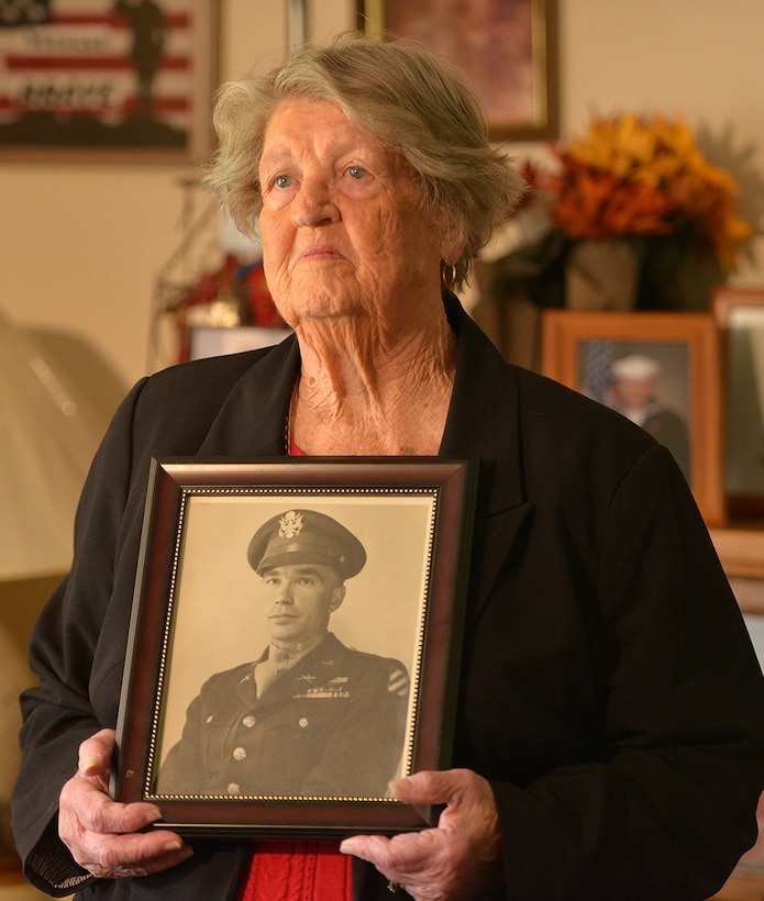 A widow holds a WWII-era photo of her husband.