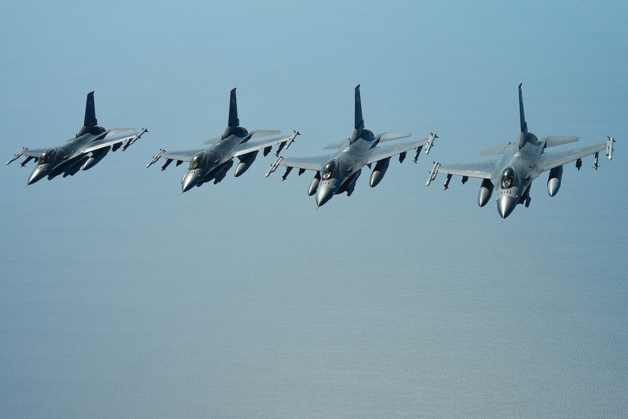 U.S. Air Force pilots assigned to the 77th Fighter Squadron navigate F-16 Fighting Falcons in formation over the Atlantic Ocean, June 20, 2018.