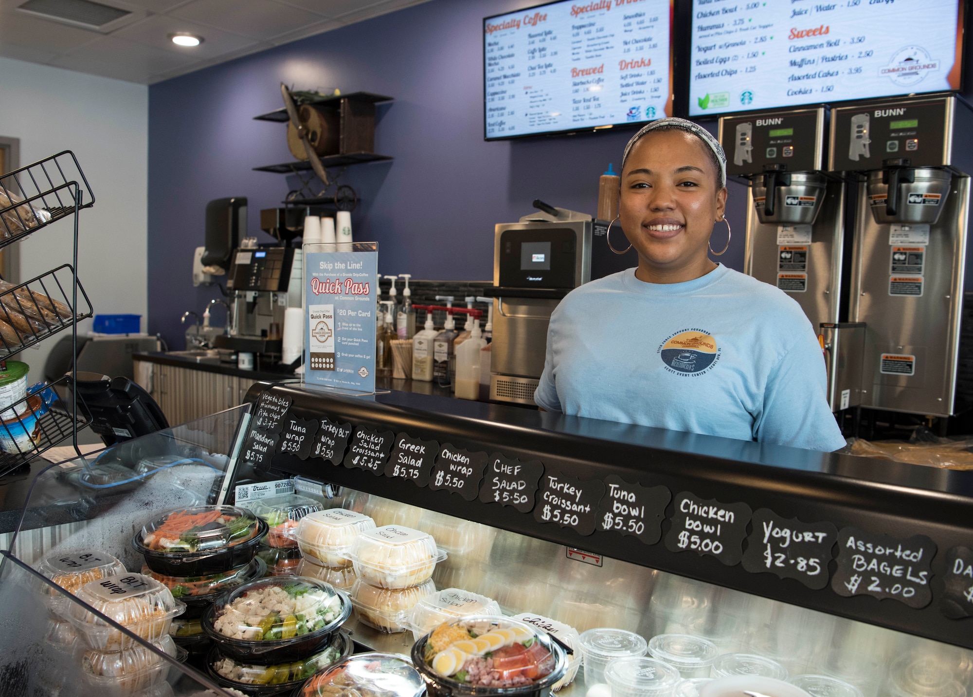 Tisha Hicks, Common Grounds server, stands behind a food display June 25th, 2018, at Scott Air Force Base, Illinois. Common Grounds will be one of the facilities that Airmen can use for dining once the Food 2.0 initiative begins. Others include: Zeppelins, Stars and Stripes Bowling Center, Rickenbackers and Cardinal Creek Golf Course. (U.S. Air Force photo by Senior Airman Melissa Estevez)