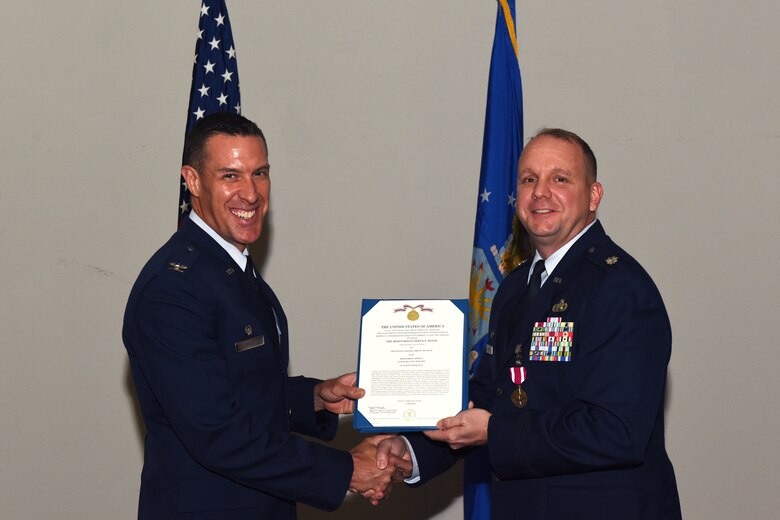 U.S. Air Force Col. Jason Beck, 17th Mission Support Group commander, presents a Meritorious Service Medal certificate to Lt. Col. John Travieso, 17th Contracting Squadron outgoing commander, during the 17th CONS Change of Command ceremony at the Event Center on Goodfellow Air Force Base, Texas, June 25, 2018. In fiscal year 17, Travieso’s small team of 37 accounted for 64 percent of all Air Education Training Commands’ savings. (U.S. Air Force photo by Airman 1st Class Zachary Chapman/Released)