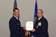 U.S. Air Force Col. Jason Beck, 17th Mission Support Group commander, presents a Meritorious Service Medal certificate to Lt. Col. John Travieso, 17th Contracting Squadron outgoing commander, during the 17th CONS Change of Command ceremony at the Event Center on Goodfellow Air Force Base, Texas, June 25, 2018. In fiscal year 17, Travieso’s small team of 37 accounted for 64 percent of all Air Education Training Commands’ savings. (U.S. Air Force photo by Airman 1st Class Zachary Chapman/Released)