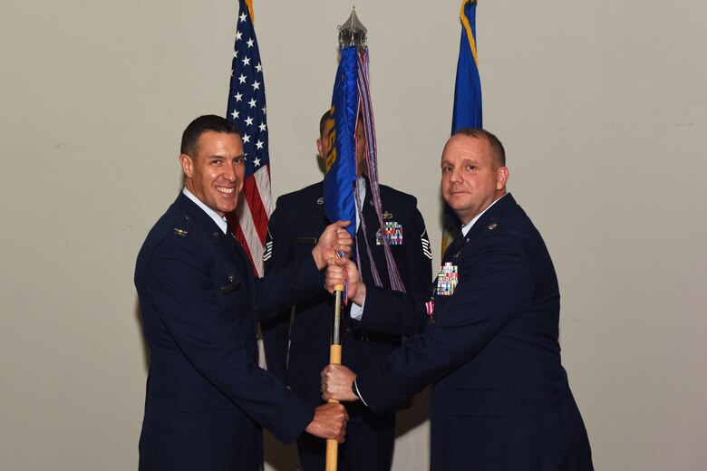 U.S. Air Force Col. Jason Beck, 17th Mission Support Group commander, accepts the 17th Contracting Squadron guideon from Lt. Col. John Travieso, 17th CONS outgoing commander, during the 17th CONS Change of Command ceremony at the Event Center on Goodfellow Air Force Base, Texas, June 25, 2018. The change of command ceremony is a time honored military tradition that signifies the orderly transfer of authority. (U.S. Air Force photo by Airman 1st Class Zachary Chapman/Released)