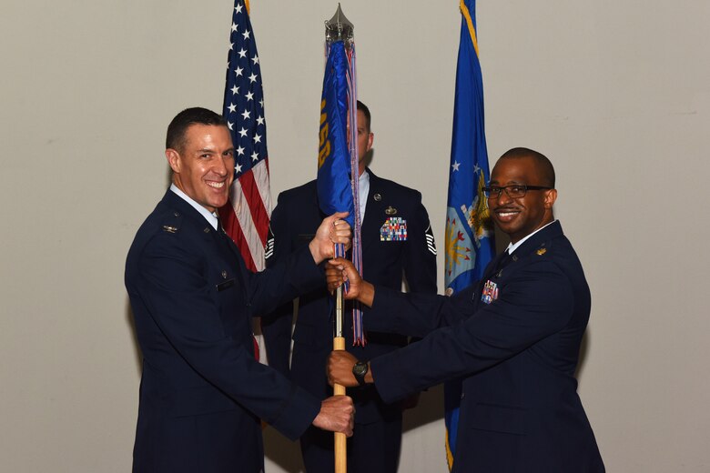 U.S. Air Force Col. Jason Beck, 17th Mission Support Group commander, passes the 17th Contracting Squadron guideon to Maj. Michael Quinn, 17th CONS incoming commander, at the 17th CONS Change of Command ceremony at the Event Center on Goodfellow Air Force Base, Texas, June 25, 2018. The guideon signifies the passing of command from one commander to the next. (U.S. Air Force photo by Airman 1st Class Zachary Chapman/Released)