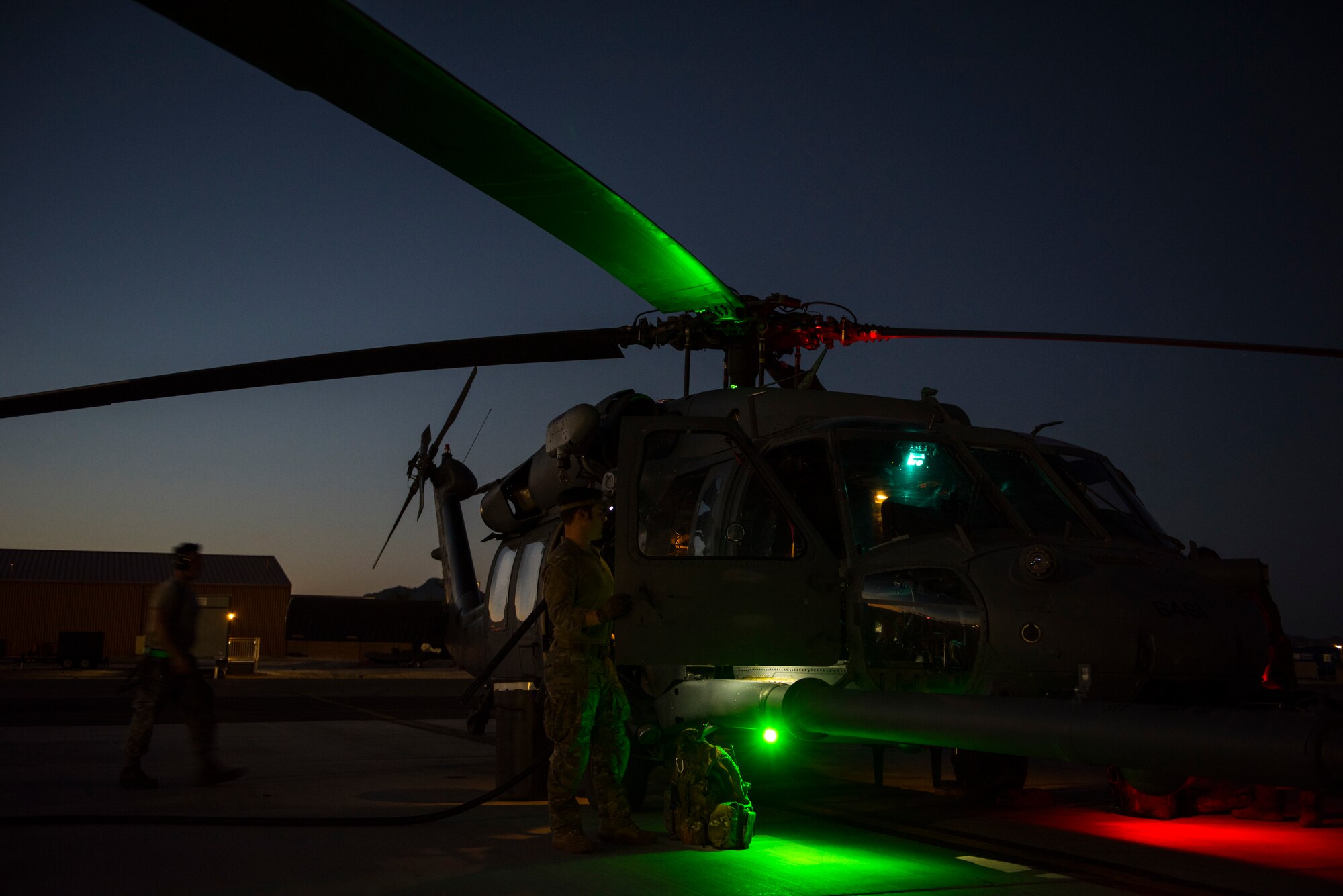 A crew prepares an HH-60G Pave Hawk helicopter prior to a large-scale U.S. Air Force Weapons School Integration Phase training exercise June 11, 2018 at Nellis Air Force Base, Nev. The USAFWS trains tactical experts and leaders to control and exploit air, space and cyberspace assets on behalf of the joint force. (U.S. Air Force photo by Staff Sgt. Joshua Kleinholz)