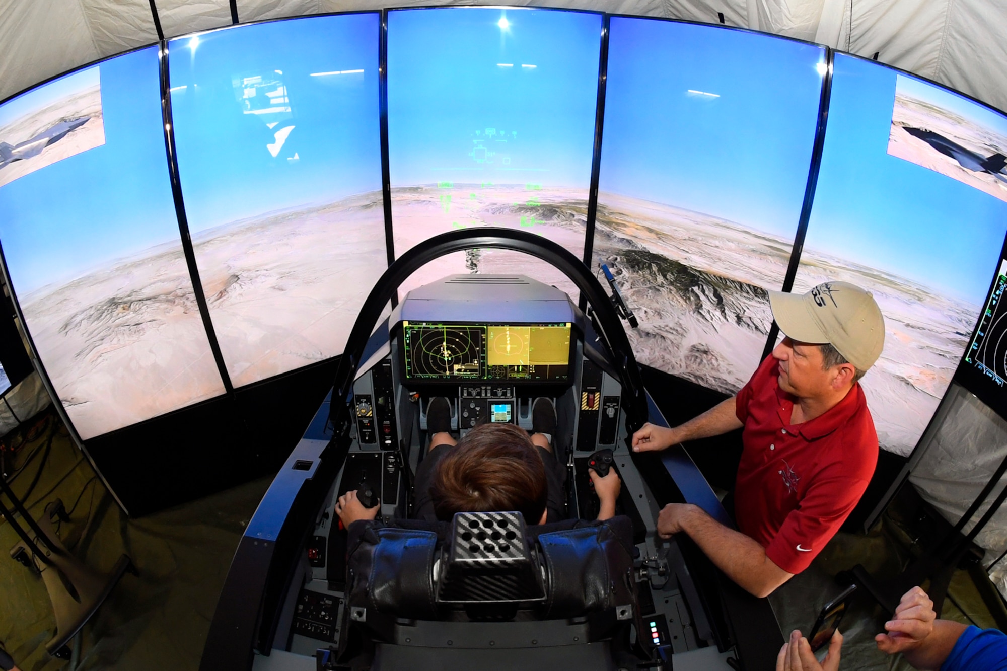 Air show visitors experience a Lockheed Martin F-35 simulator June 24, 2018, at Hill Air Force Base, Utah. Some of the largest aerospace companies in the world brought interative exhibits and displays to the Warriors Over the Wasatch Air and Space Show. (U.S. Air Force photo by Todd Cromar)