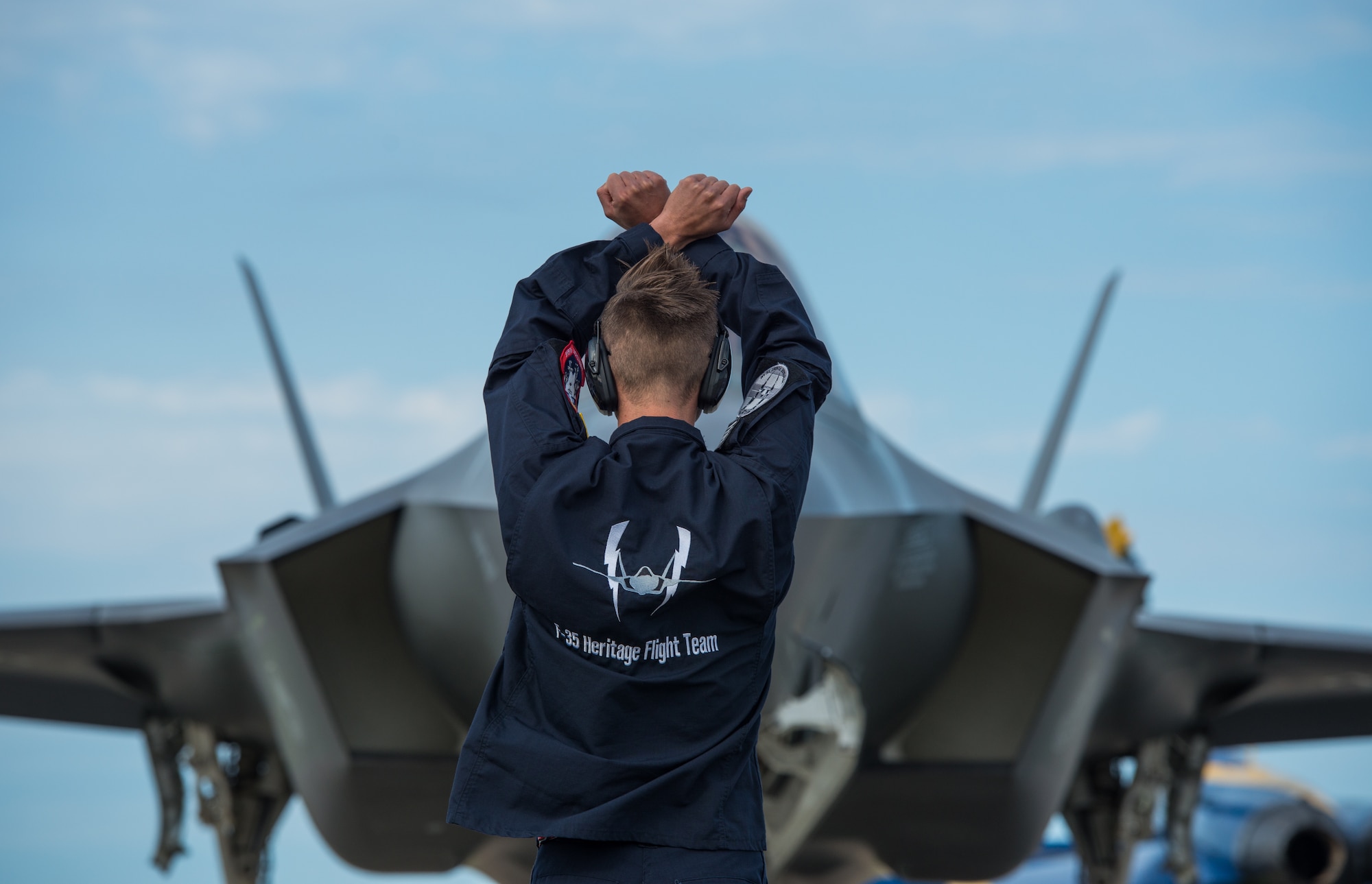 Staff Sgt. Zachary Madera, F-35 Heritage Flight Team crew chief, marshals an F-35A Lightning II at the Quonset State Airport in North Kingstown, R.I., June 7, 2018. Throughout the air show season, the F-35 HFT will perform at 13 air shows around the world. (U.S. Air Force photo by Airman 1st Class Alexander Cook)