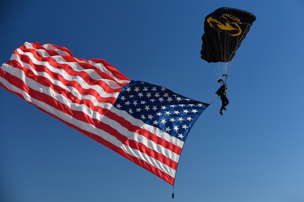A U.S. Special Operations Command Para-Commando parachute demonstration member parahutes in to the Warriors Over the Wasatch Air and Space Show carrying the American flag June 24, 2018, at Hill Air Force Base, Utah. (U.S. Air Force photo by Todd Cromar)