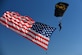 A U.S. Special Operations Command Para-Commando parachute demonstration member parahutes in to the Warriors Over the Wasatch Air and Space Show carrying the American flag June 24, 2018, at Hill Air Force Base, Utah. (U.S. Air Force photo by Todd Cromar)