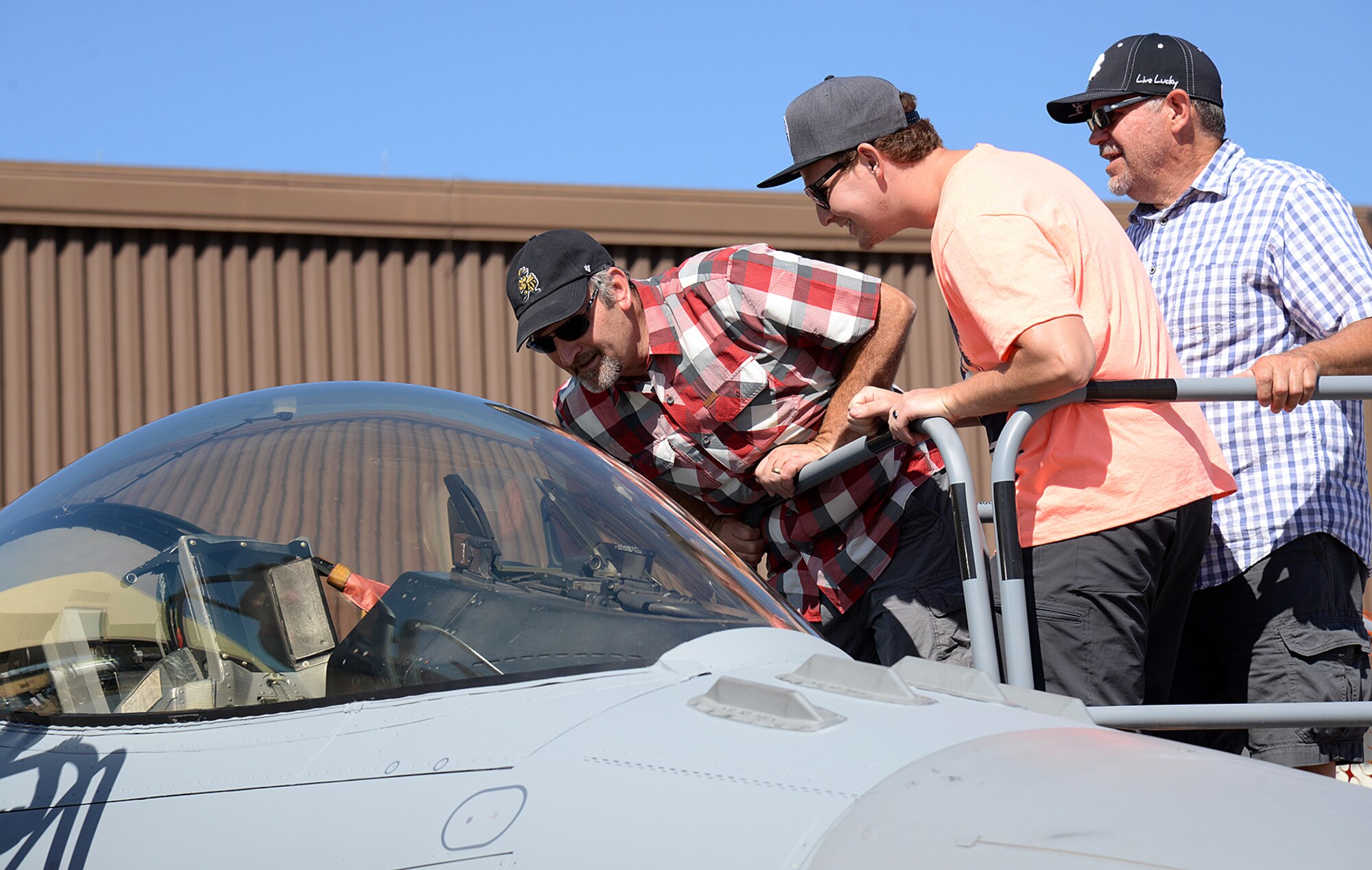 Patrons attending the Warriors over the Wasatch Air and Space Show peer inside the cockpit of an F-16C cockpit at Hill Air Force Base, Utah, June 23, 2018. The F-16 recently received depot maintenance modifications at Hill's Ogden Air Logistics Complex and will be returned to its home unit after the air show.  (U.S. Air Force photo by Alex R. Lloyd)