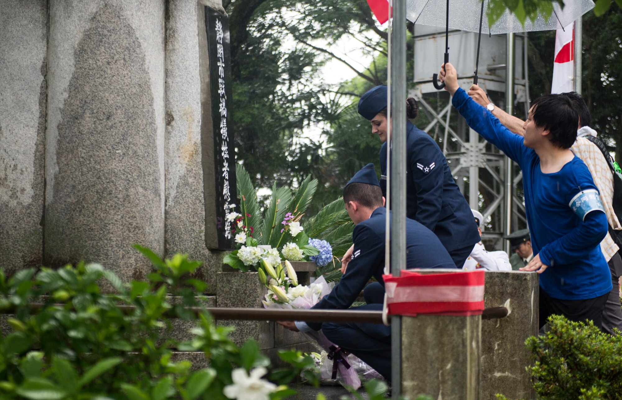 Yokota Air Base members place flowers at the Japanese memorial