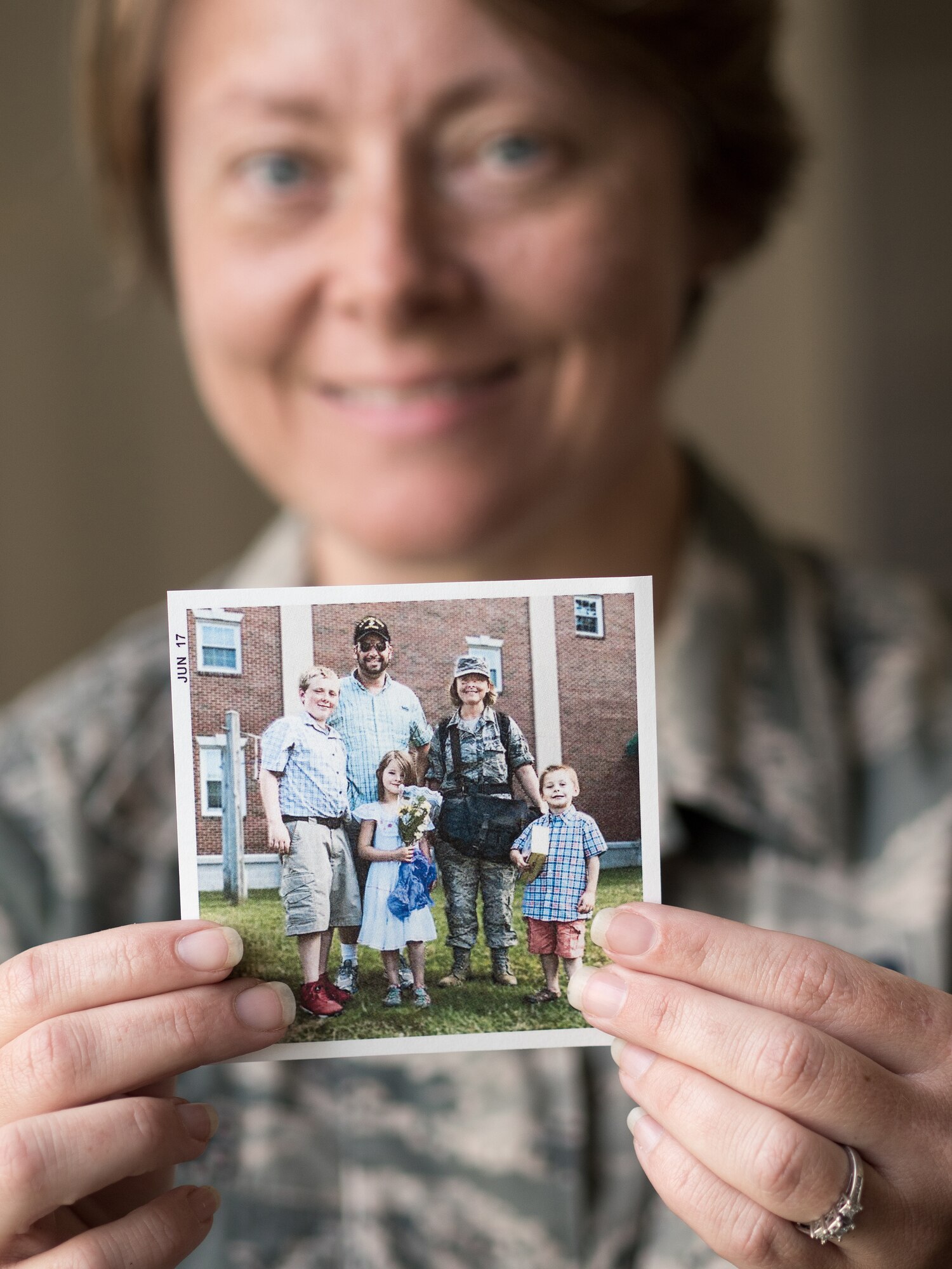 Airman 1st Class Crystal Jenkins, a photojournalist assigned to the 673d Air Base Wing Public Affairs unit, holds a photo of her and her family after she graduated from Defense Information School at Fort Meade, Md., in 2017. Jenkins was inspired to join the U.S. Air Force during the 2016 Arctic Thunder Open House at Joint Base Elmendorf-Richardson, Alaska. After enlisting in 2016 she was given the opportunity to return to the base she was recruited from.