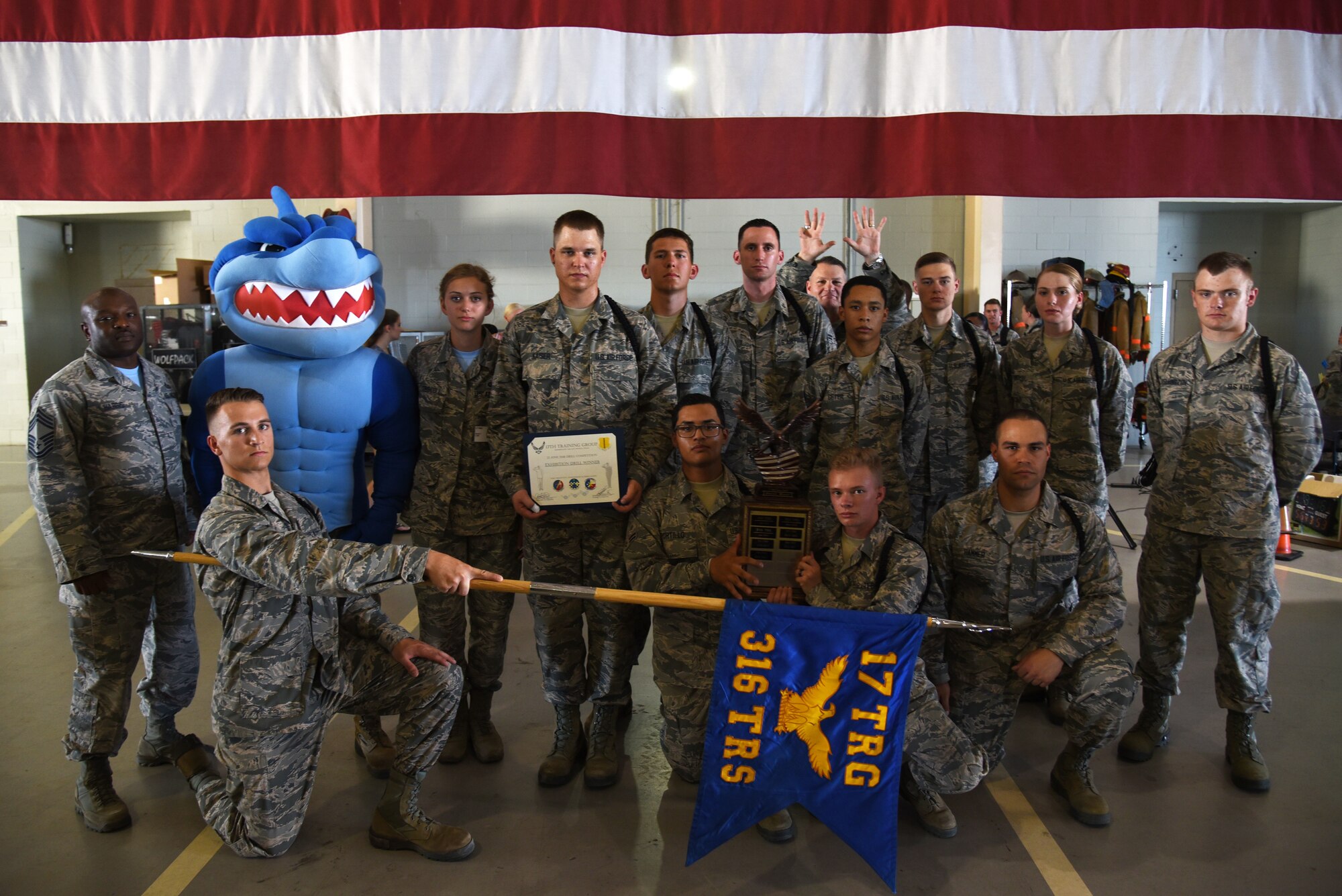 The 316th Training Squadron drill team poses with the first place overall award of the 17th Training Group drill competition at the Louis F. Garland Department of Defense Fire Academy on Goodfellow Air Force Base, Texas, June 22, 2018. To win the overall drill award the team had to score the most points in regulation and exhibition drill forms. (U.S. Air Force photo by Staff Sgt. Joshua Edwards/Released)