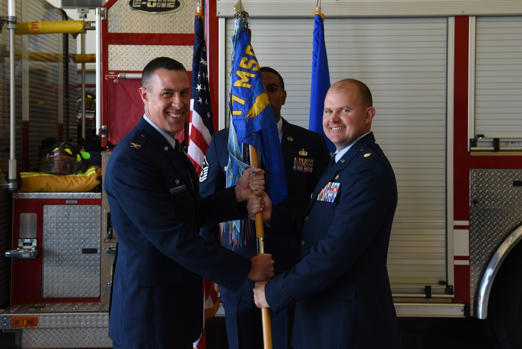 U.S. Air Force Col. Jason Beck, 17th Mission Support Group commander, passes the 17th Civil Engineer Squadron guideon to Maj. Nicholas Anderson, 17th CES commander, during the 17th CES Assumption of Command at the fire department on Goodfellow Air Force Base, Texas, June 22, 2018. As the 17th CES commander, Anderson is responsible for providing for the facilities, infrastructure and services on the base. (U.S. Air Force photo by Staff Sgt. Joshua Edwards/Released)