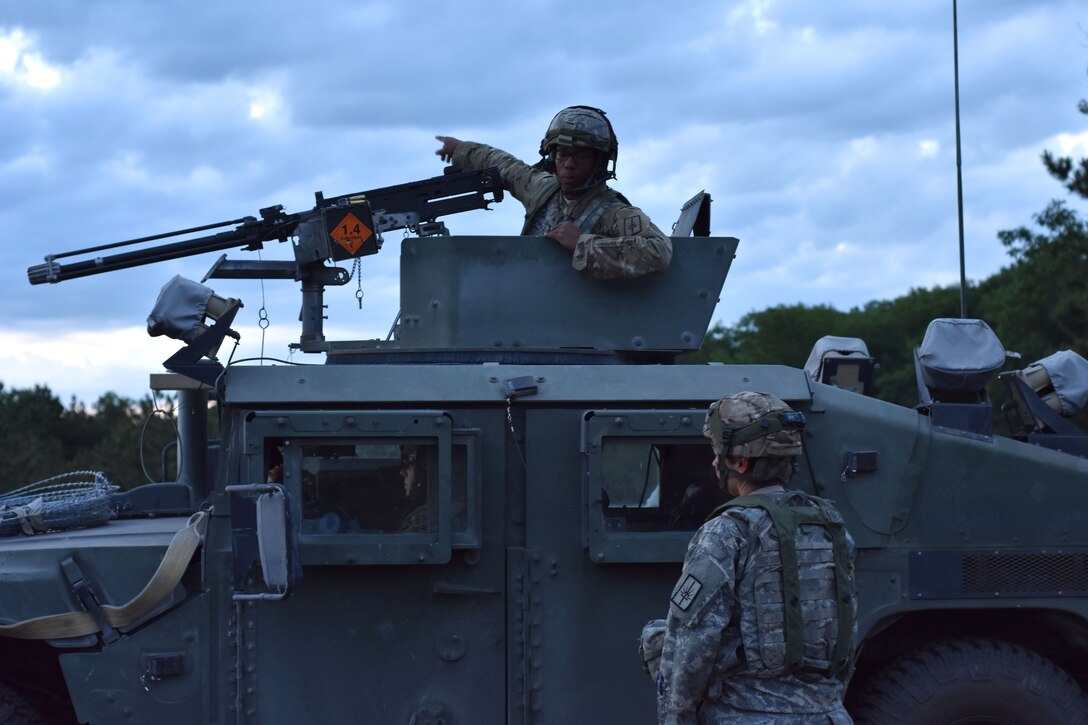 A soldier in a Humvee discusses relocating their Humvee with his team leader.