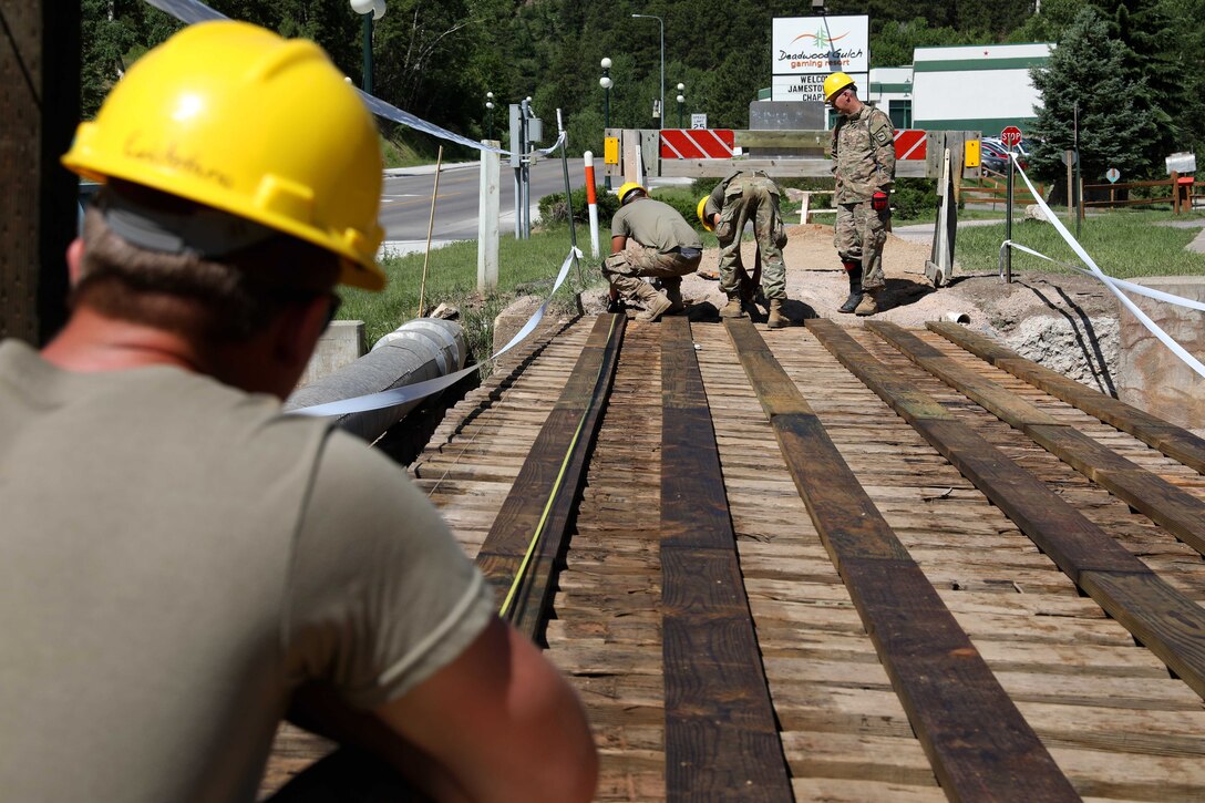 U.S. soldiers take measurements during a bridge repair project.
