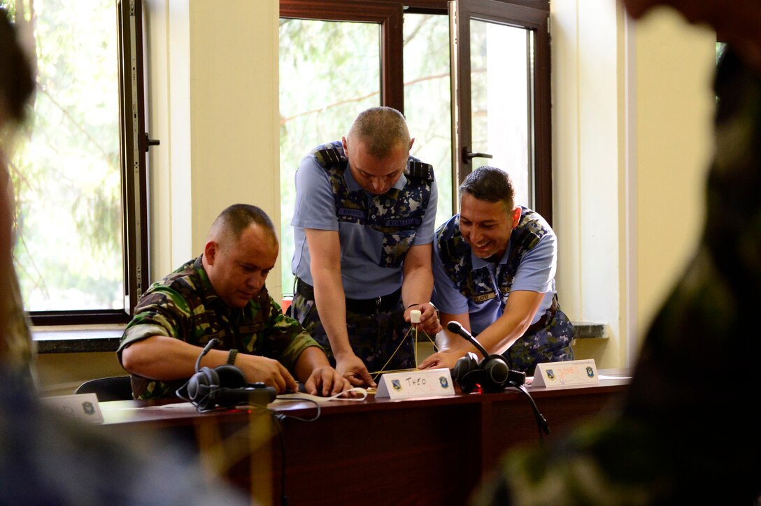 Three Romanian Air Force students participate in a strategic thinking exercise during the first-ever senior noncom missed officer mobile education course June 8 to 22, 2018, at Boboc Air Base, in Buzău, Romania. The SNCOA mobile training team partnered with the Inter-European Air Forces Academy to provide a two-week course, condensed from the full five-week course held at Maxwell Air Force Base- Gunter Annex, Alabama. (U.S. Air Force photo by Tech. Sgt. Staci Kasischke)