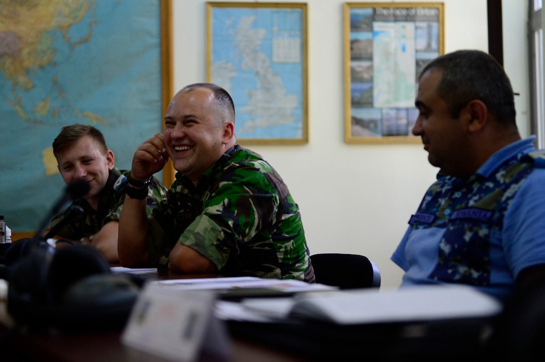 Romanian Warrant Officer Vlad Negru laughs while discussing concepts during the first-ever senior noncommissioned officer mobile education course June 8 to 22, 2018, at Boboc Air Base, in Buzău, Romania. The SNCOA mobile training team partnered with the Inter-European Air Forces Academy to provide a two-week course, condensed from the full five-week course held at Maxwell Air Force Base- Gunter Annex, Alabama. (U.S. Air Force photo by Tech. Sgt. Staci Kasischke)