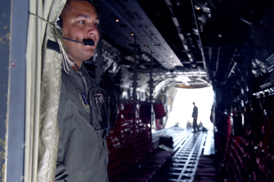 Members of the Rhode Island National Guard look out from the back of an airplane