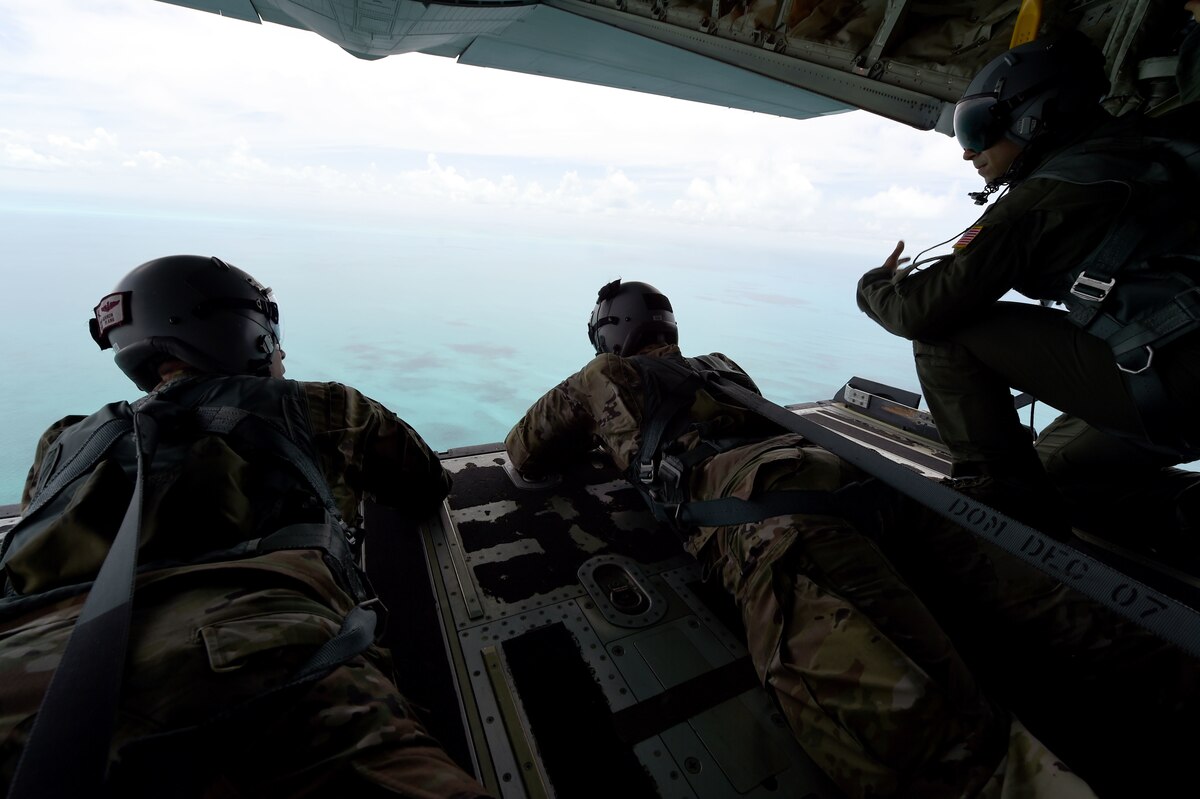 Members of the Rhode Island National Guard look out from the back of an airplane