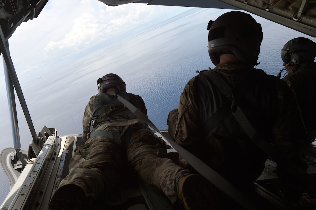 Members of the Rhode Island National Guard look out from the back of an airplane