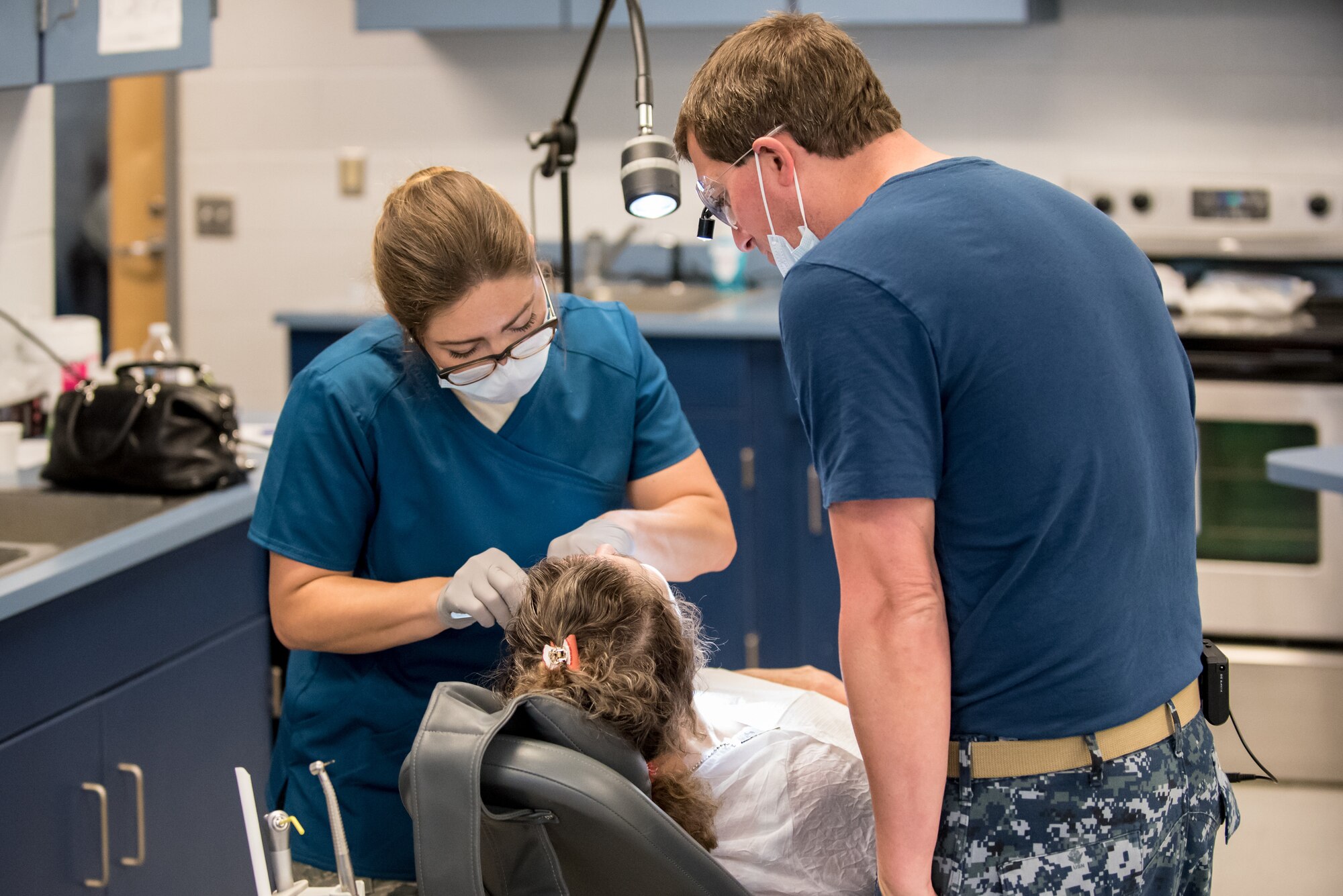 U.S. Air Force Staff Sgt. Elisabeth Runser, a dental technician from the Indiana Air National Guard’s 122nd Air Fighter Wing, and U.S. Navy Lt. Cmdr. Jeff Zimmerman from Operational Health Services Unit Pensacola in Florida, performs dental procedures on a patient at a health-care clinic being operated by the Air Guard and U.S. Navy Reserve at Estill County High School in Irvine, Ky., June 21, 2018. The clinic is one of four that comprised Operation Bobcat, a 10-day mission to provide military medical troops with crucial training in field operations and logistics while offering no-cost health care to the residents of Eastern Kentucky. The clinics, which operated from June 15-24, offered non-emergent medical care; sports physicals; dental cleanings, fillings and extractions; eye exams and no-cost prescription eye glasses. (U.S. Air National Guard photo by Lt. Col. Dale Greer)