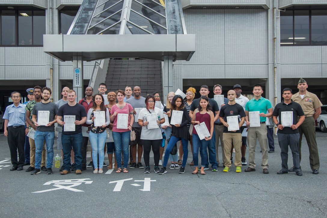 U.S. service members stationed at Marine Corps Air Station Iwakuni pose for a photo after completing the Iwakuni Driving School class in Iwakuni City, Japan, June 23, 2018. The class, promoted through the city of Iwakuni, was held in order to educate Status of Forces Agreement drivers on common driving errors that are made in the city and how to correct them.