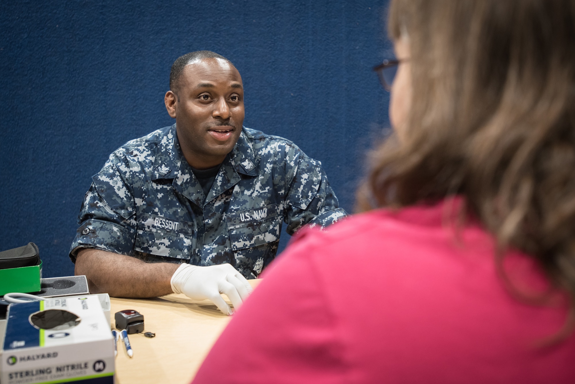 U.S. Navy HM2 Frederick Bessent, a medical support sailor from Naval Operation Support Center in Pittsburgh, takes the medical history of a local resident at a no-cost health-care clinic at Lee County High School in Beattyville, Ky., June 15, 2018. The clinic is one of four that was staffed by military health-care professionals in Eastern Kentucky from June 15 to June 24 as part of an Innovative Readiness Training mission called Operation Bobcat. The mission provided military forces with crucial expeditionary training while offering no-cost medical, dental and optometry care to area residents. (U.S. Air National Guard photo by Lt. Col. Dale Greer)