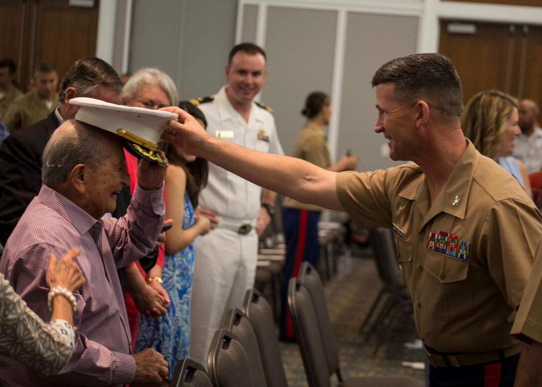 Colonel Jeffrey C. Smitherman, Commanding Officer of 6th Marine Corps District, hands his cover to an attendant of the Recruiting Station Jacksonville change of command ceremony in Jacksonville, Florida, June 22, 2018. During the ceremony, Maj. Michael Valenti, the outgoing commanding officer for RS Jacksonville, will relinquish his command to Maj. Joseph Gill.