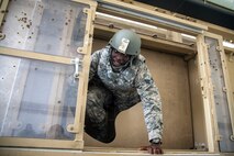An Airman from the 23d Civil Engineer Squadron (CES), climbs out of a mine-resistant, ambush-protected vehicle roll-over simulator (MRAP) during tactical convoy operations training, June 21, 2018, at Moody Air Force Base, Ga. For the first time at Moody, 820th Base Defense Group personnel equipped 23d CES Airmen with convoy operations skills to efficiently perform MRAP evacuations. (U.S. Air Force photo by Airman 1st Class Eugene Oliver)