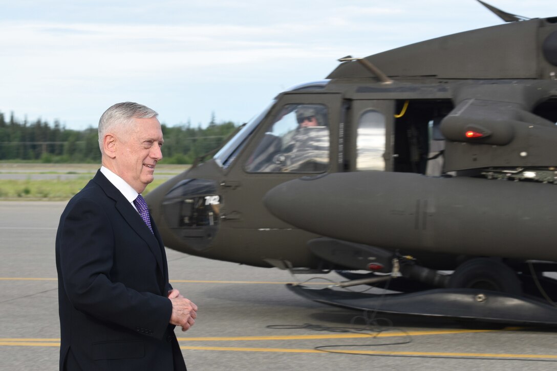 Defense Secretary James N. Mattis walks by a UH-60 Black Hawk helicopter