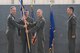 Col. Christopher Spinelli, 412th Operations Group commander (left), passes the 416th Flight Test Squadron guidon to Lt. Col. Scott Fann during a change of command ceremony June 1 in Hangar 1207. Fann takes over the squadron from Lt. Col. Chris Keithley (right) who commanded the squadron for the past two years. (U.S. Air Force photo by Don Allen)