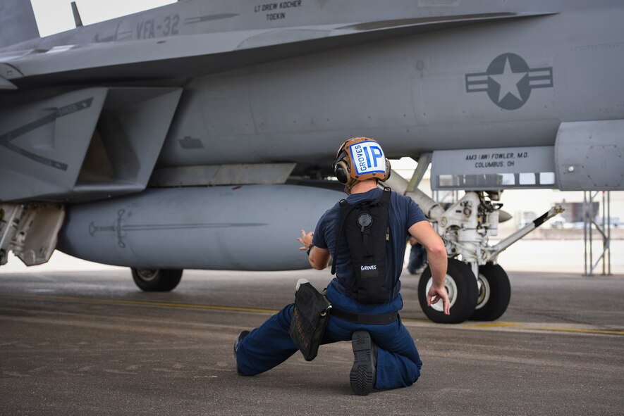 A sailor from the Naval Air Station Oceana directs an F/A-18 assigned to Strike Fighter Squadron (VFA) 32 during training June 18, 2018, at Eglin Air Force Base, Fla. This training gives the Navy pilots and maintainers the opportunity to work in a different environment which is crucial for deployments. (U.S. Air Force photo by Airman 1st Class Daniella Peña-Pavao)