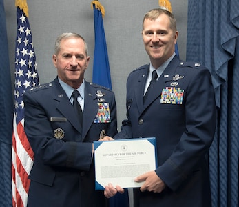Lt. Col Daniel Finnegan receives the Koren Kolligian Trophy certificate from Air Force Chief of Staff Gen. David L. Goldfein in the Pentagon, Arlington, Va., June 25, 2018. (U.S. Air Force photo by Wayne A. Clark)