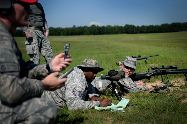 (Right) Senior Airman Jennifer Gamez, 19th Security Forces Squadron installation entry controller, prepares to fire an M24 sniper weapon system at a range on Camp Robinson, Ark., June 6, 2018. Gamez waited for her spotter to provide her with the best shot on target for her advanced designated marksman qualification. (U.S. Air Force photo by Airman 1st Class Kristine M. Gruwell)