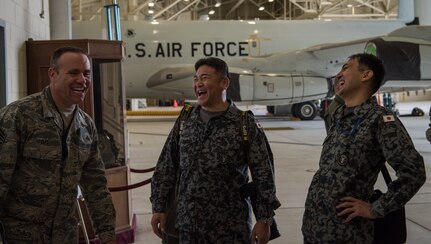 U.S. Air Force Chief Master Sgt. Mike Day, 962nd Airborne Air Control Squadron superintendent, Japan Air Self-Defense Force Warrant Officer Tomoyo Kobayashi (middle) and JASDF senior enlisted advisor Warrant Officer Masahiro Yokota share a laugh at Joint Base Elmendorf-Richardson, Alaska, June 19, 2018. During their visit, Kobayashi and Yokota toured the installation and oversaw JASDF Airmen working alongside American forces during Pacific Air Forces’ premier air combat exercise, Red Flag-Alaska, iteration 18-2.