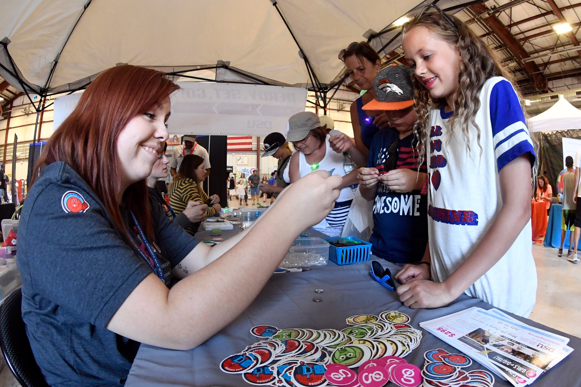 Lilly and Kolton Romney (right) assemble LED badges with help from Kennedy Velasquez at the “Girls go Digital!” booth during the Warriors Over the Wasatch Air and Space Show, June 24, 2018, at Hill Air Force Base, Utah. The booth was one of numerous exhibits and activities associated with STEM City at the Hill Air Show June 23-24, an area dedicated to encouraging students and educating parents about opportunities in science, technology, engineering and math.(U.S. Air Force Photo by Todd Cromar)