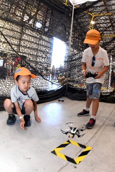 James Che (left) watches his friend Ethan Tang fly a drone during the Warriors Over the Wasatch Air and Space Show June 24, 2018, at Hill Air Force Base, Utah. The drone play area was one of numerous exhibits and activities associated with STEM City at the Hill Air Show June 23-24, an area dedicated to encouraging students and educating parents about opportunities in science, technology, engineering and math.(U.S. Air Force Photo by Todd Cromar)