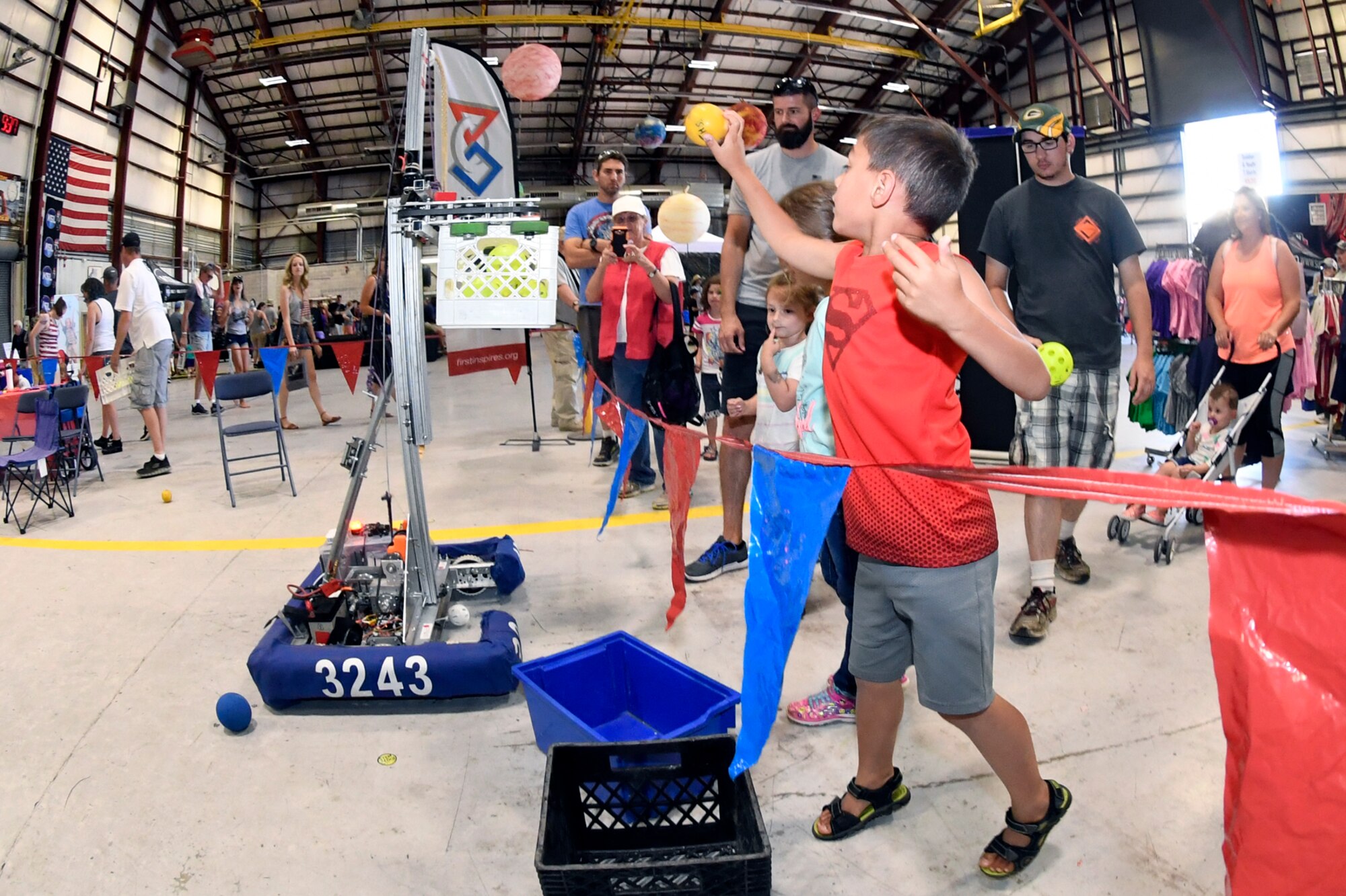 Dakota Baker throws a ball into a basket attached to a moving robot at the “First Is” display during the Warriors Over the Wasatch Air and Space Show June 24, 2018, at Hill Air Force Base, Utah. The diplay was one of numerous exhibits and activities associated with STEM City at the Hill Air Show June 23-24, an area dedicated to encouraging students and educating parents about opportunities in science, technology, engineering and math.(U.S. Air Force Photo by Todd Cromar)