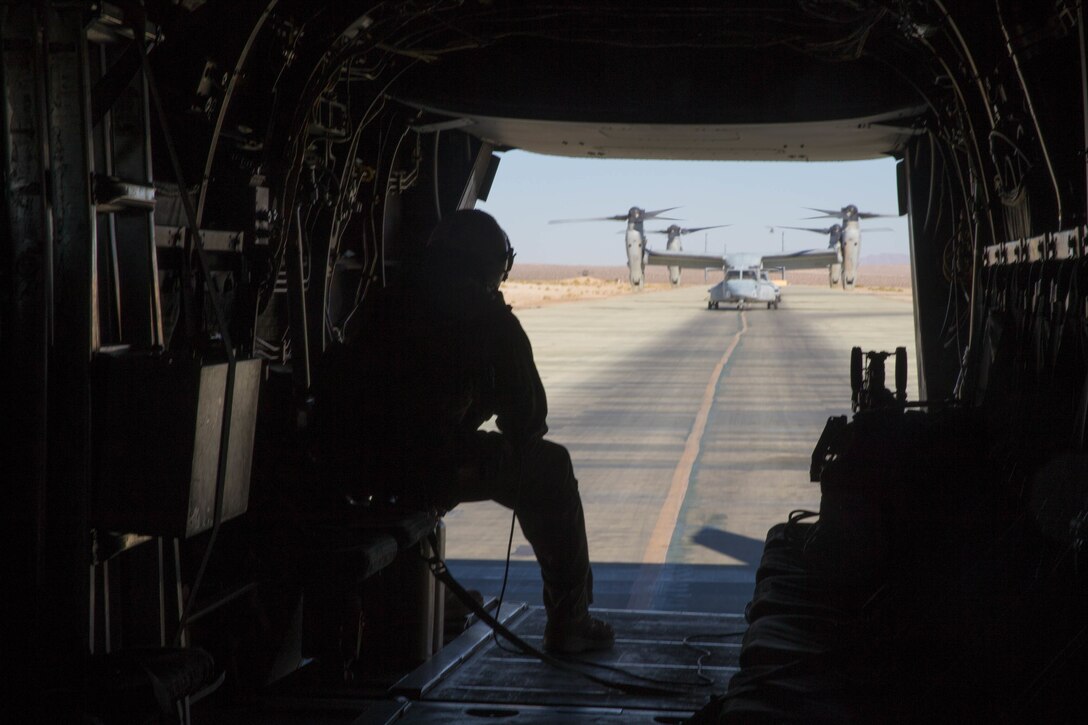 Cpl. Chase Clark, a tiltrotor crew chief with Marine Medium Tiltrotor Squadron 764, Marine Aircraft Group 41, 4th Marine Aircraft Wing, looks out the back hatch before take off in an MV-22B Osprey, during Integrated Training Exercise 4-18 at Marine Corps Air Ground Combat Center Twentynine Palms, Calif., June 23, 2018. VMM-764, known as “moonlight,” is based out of Marine Corps Air Station Miramar and provided air combat element support to Marine Air Ground Task Force 23 during ITX 4-18. (U.S. Marine Corps photo by Lance Cpl. Samantha Schwoch/released)