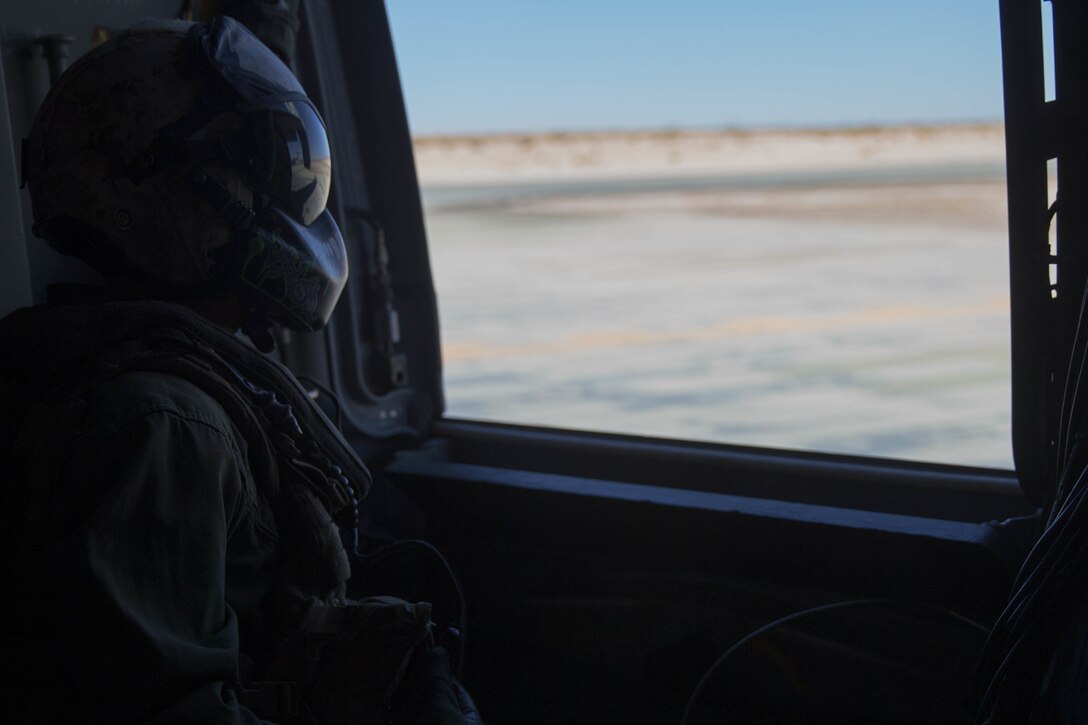 Sgt. Cristian Chevez, a tiltrotor crew chief with Marine Medium Tiltrotor Squadron 764, Marine Aircraft Group 41, 4th Marine Aircraft Wing, looks out the side hatch before take off in an MV-22B Osprey during Integrated Training Exercise 4-18, at Marine Corps Air Ground Combat Center Twentynine Palms, Calif., June 23, 2018. VMM-764, known as “moonlight,” is based out of Marine Corps Air Station Miramar and provided air combat element support to Marine Air Ground Task Force 23 during ITX 4-18. (U.S. Marine Corps photo by Lance Cpl. Samantha Schwoch/released)