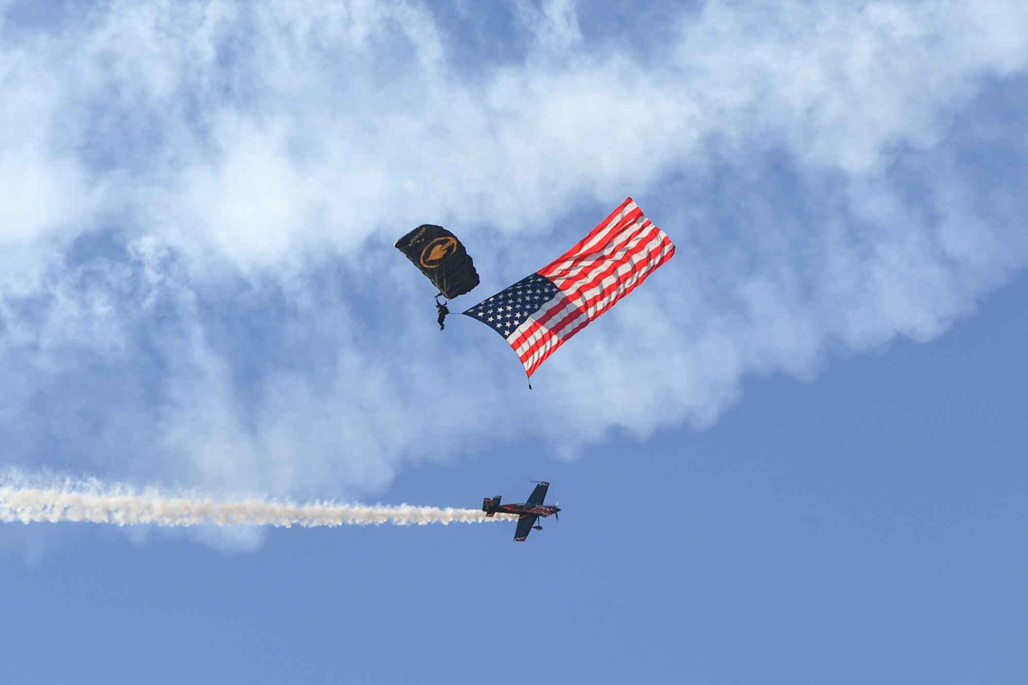 A U.S. Special Operations Command The Para-Commandos parachute demonstration team member performs a National Anthem flag jum during the Warriors Over the Wasatch Air and Space Show June 24, 2018, at Hill Air Force Base, Utah. The Para-Commandos are comprised of active duty special operators, such as Army Special Forces, Army Rangers, Navy SEALs, Air Force Combat Controllers and Marine Raiders. (U.S. Air Force photo by Cynthia Griggs)