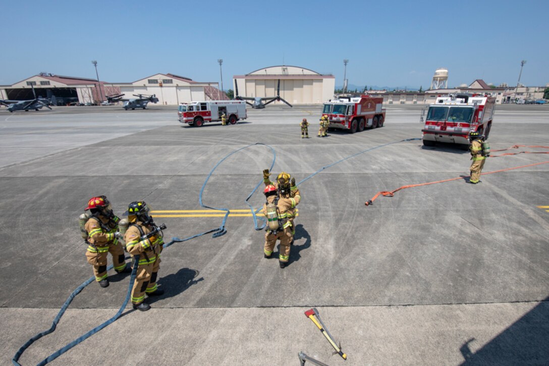 Firefighters with the 374th Civil Engineer Squadron prepare to battle a simulated fire aboard a C-17 Globemaster III during an Emergency Response Exercise