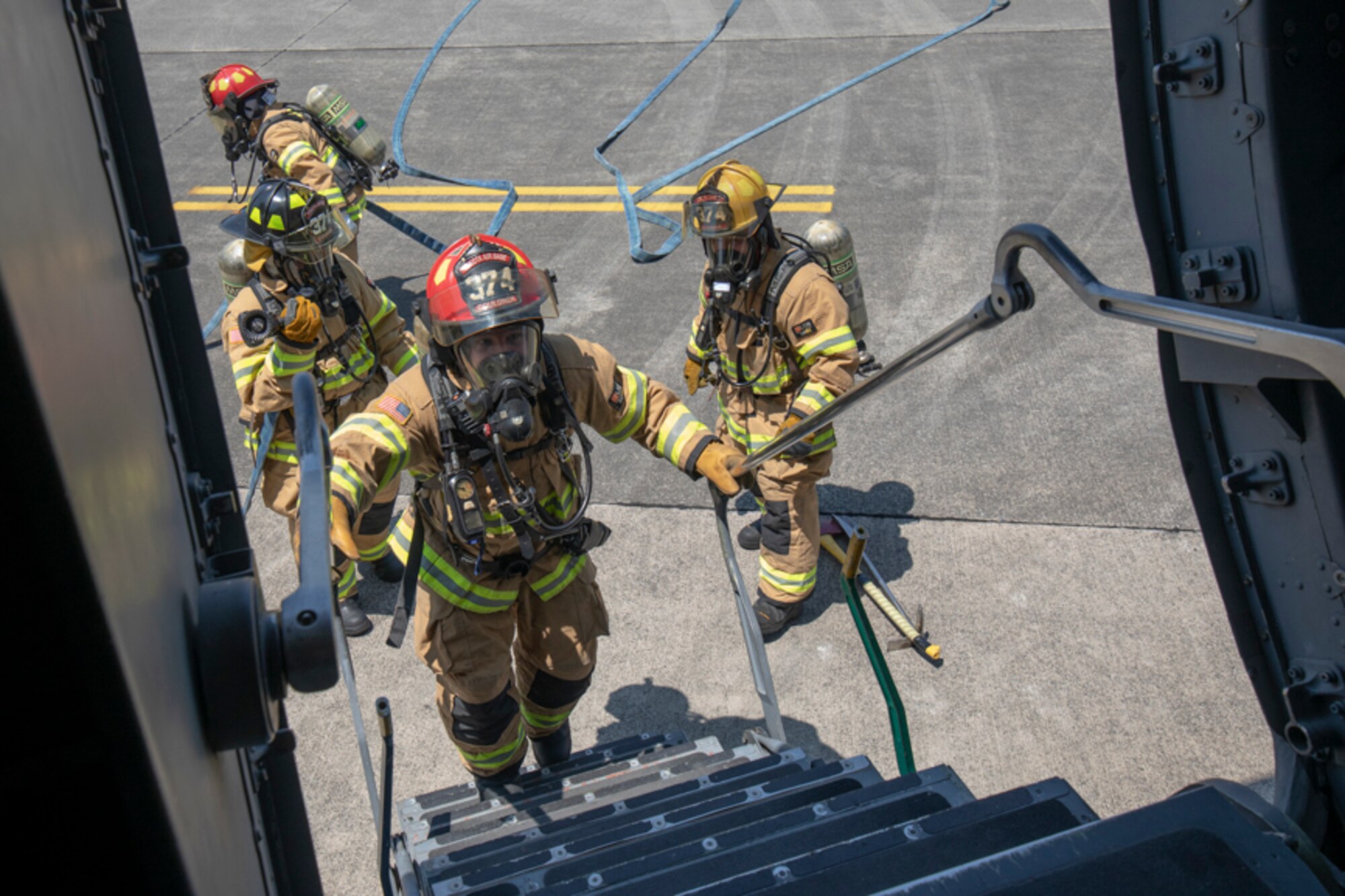Staff Sgt. Lucas Gouldner, 374th Civil Engineer Squadron fire inspector, boards the aircraft in response to a simulated fire aboard a C-17 Globemaster III