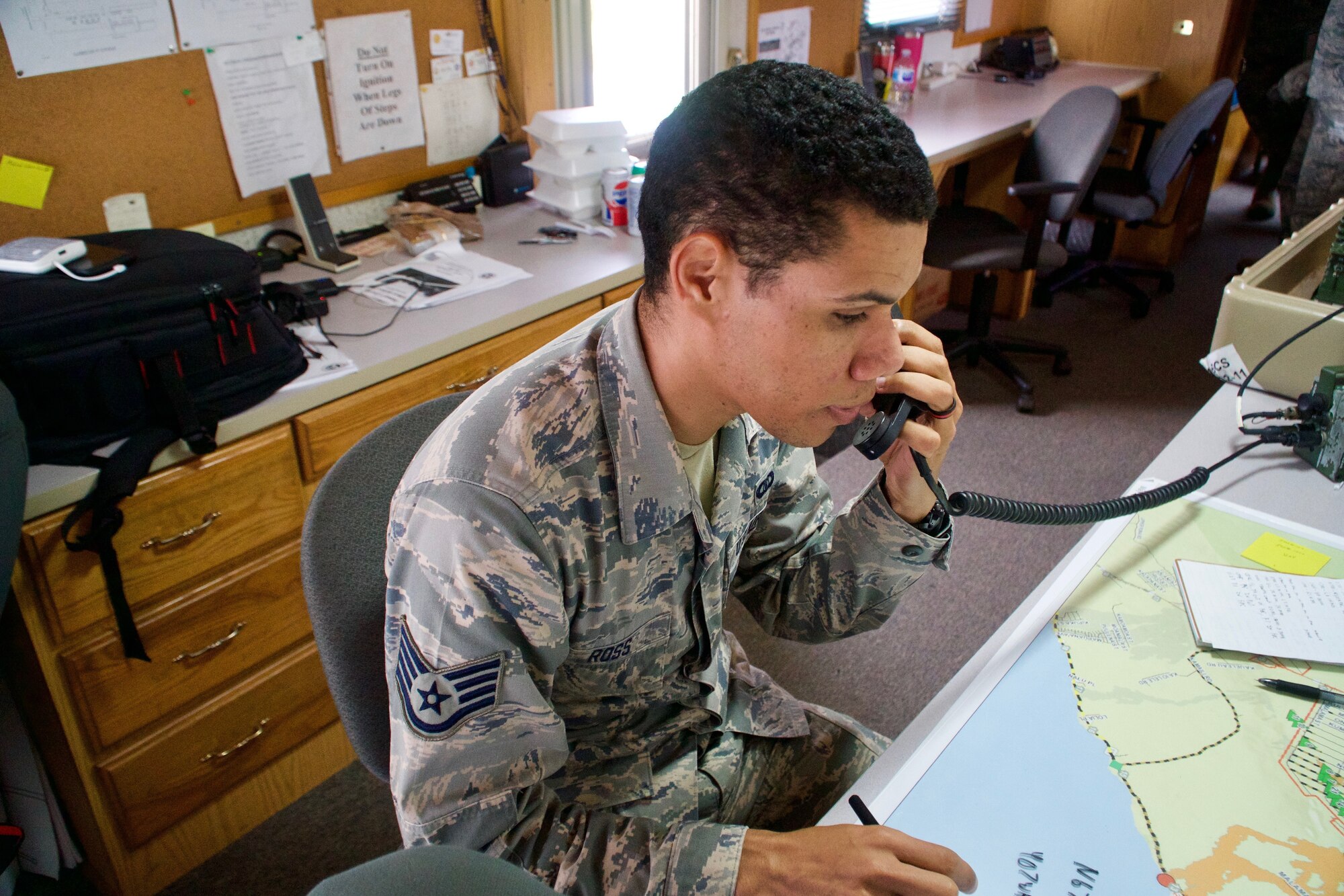 Staff Sgt. Skyler Ross, Air Traffic Control Specialist for the 297th Air Traffic Control Squadron, writes down the callsign of the civilian helicopter pilot as he checks into the temporary flight restriction airspace in Pahoa, June 8, 2018. Air Traffic Controllers closely monitor the TFR airspace to ensure all missions are completed on time and safely.