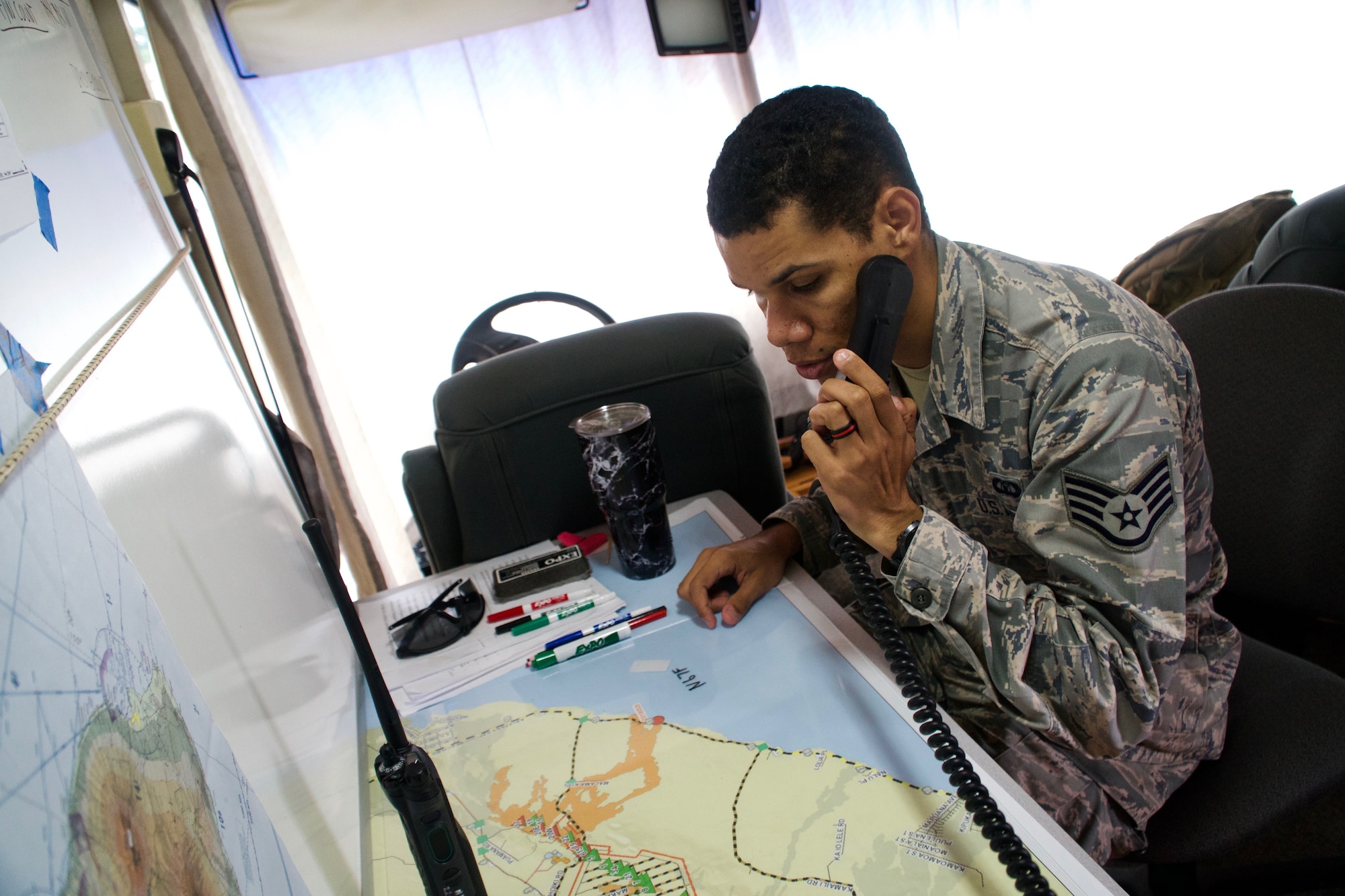 Staff Sgt. Skyler Ross, Air Traffic Control Specialist for the 297th Air Traffic Control Squadron, communicates over a VHF frequency with a civilian helicopter pilot as he checks into the temporary flight restriction airspace in Pahoa, June 8, 2018