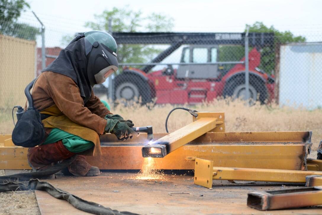 Navy Logistics Specialist 2nd Class Jeff Leet uses a plasma cutter during Defense Logistics Agency Disposition Services Overseas Contingency Operations Readiness Training  June 19 at Fort Custer, Michigan. Photo by Air Force Master Sgt. J. Scott Mathews.
